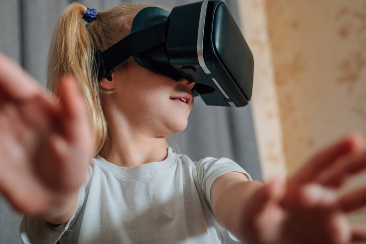 图为一个戴着VR头显的小女孩 