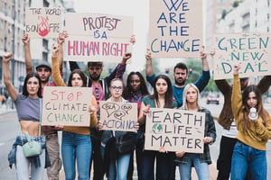 image shows a group of students holding climate aware signs.