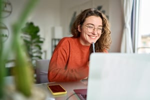 a female student on a laptop smiling