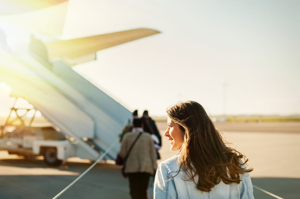 image shows a female student about to board a plane