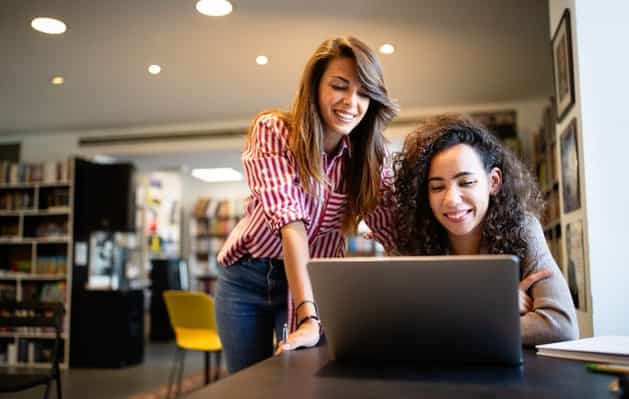 Two female students looking at a laptop