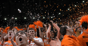 sports fans wearing orange in a crowd cheering