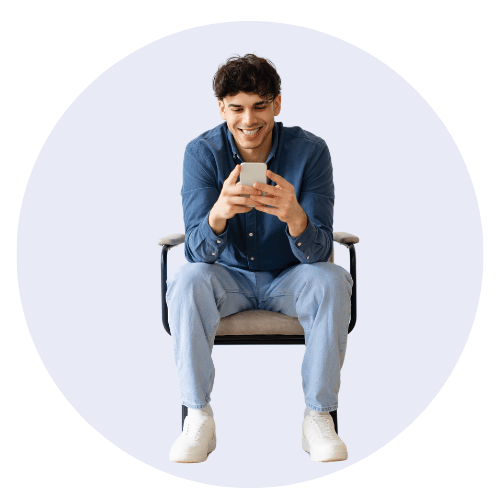 man sitting on chair looking at mobile phone
