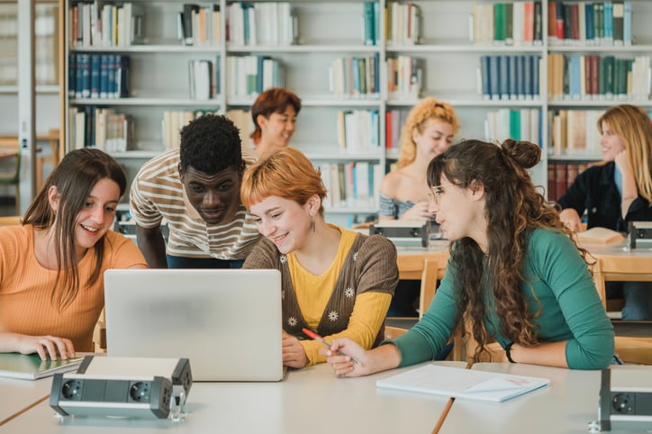 photo shows students gathered around a laptop