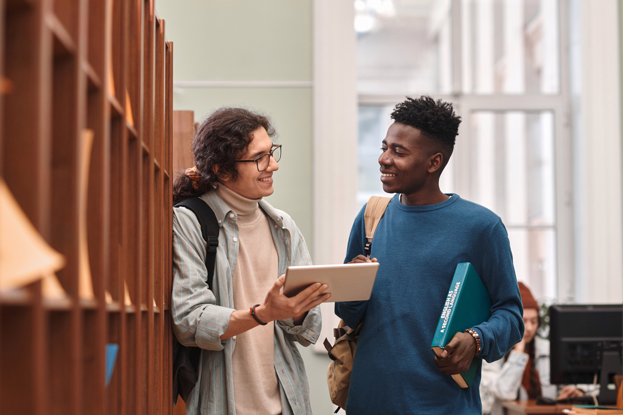 Image shows two male students in the library