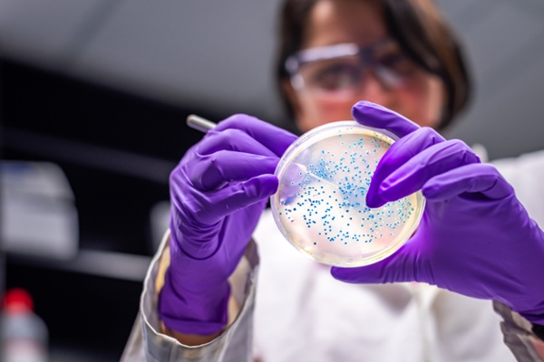 image of female looking at a petri dish in a lab environment